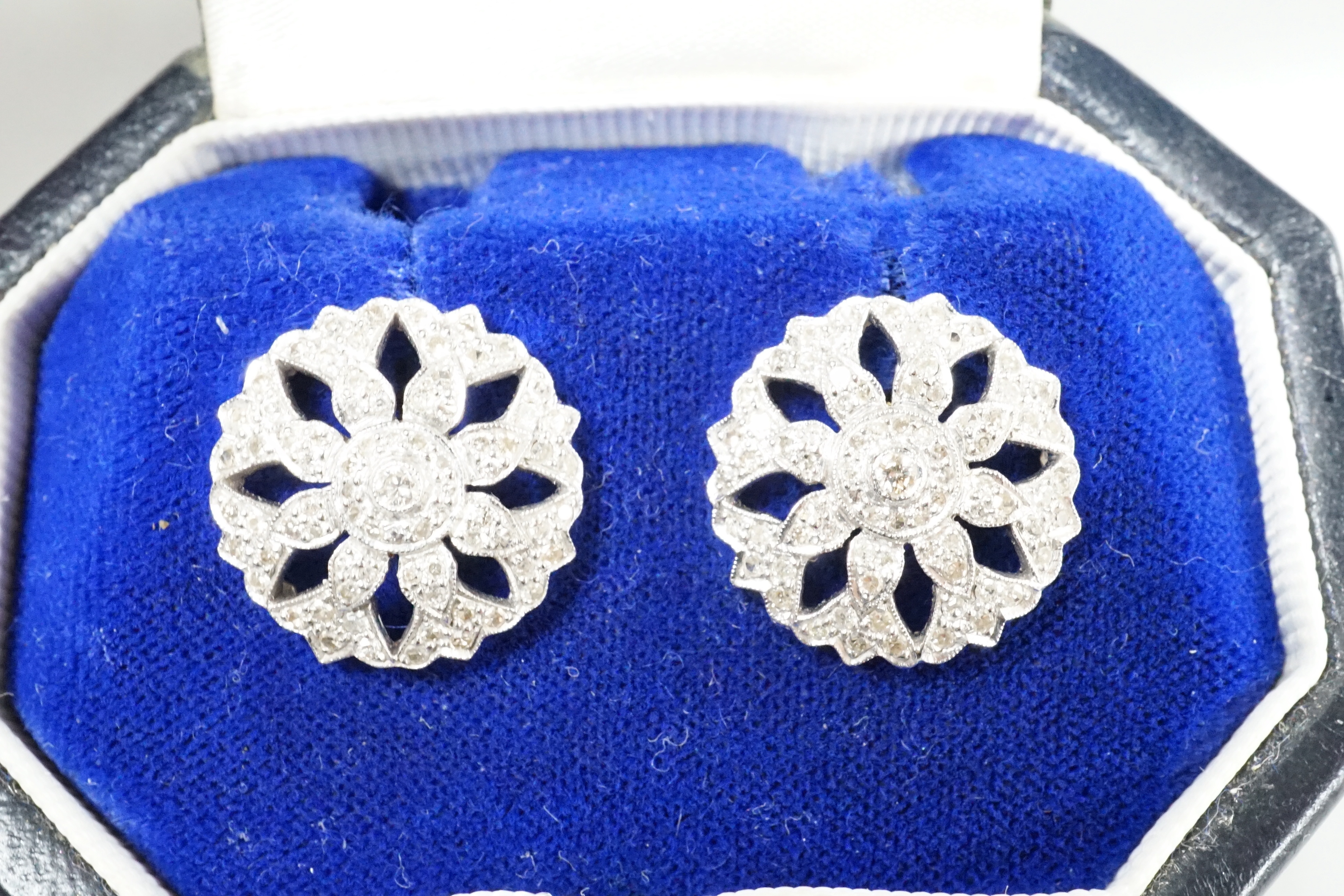 A pair of pierced white metal and diamond set circular cluster earrings, diameter 17mm, with 925 butterflies, gross weight 6.7 grams.